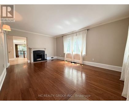 A spacious living room with hardwood floors and a fireplace.