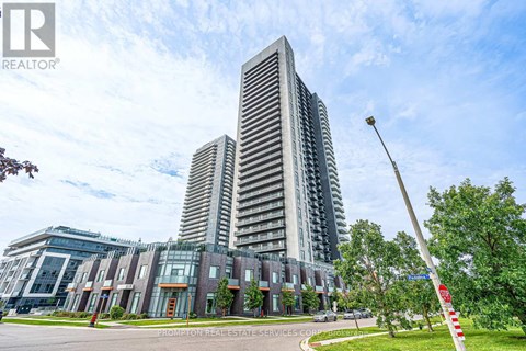 A tall building with a glass facade stands in front of a smaller building with a brick facade.