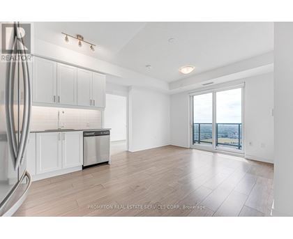 A spacious kitchen with white cabinets and a dishwasher in a room with a view.