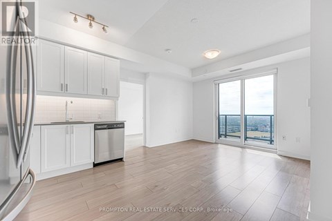 A spacious kitchen with white cabinets and a dishwasher in a room with a view.