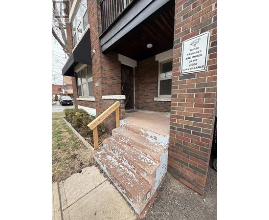 A sign on a brick building states that the premises are under 24 hour video surveillance.