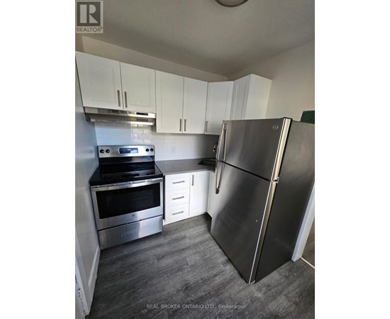 A kitchen with a stainless steel refrigerator, oven, and microwave.