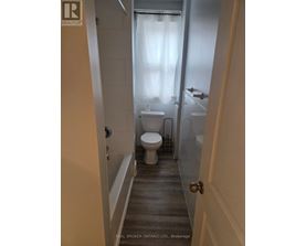A bathroom with a toilet, sink and bathtub.