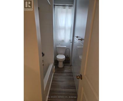 A bathroom with a toilet, sink and bathtub.