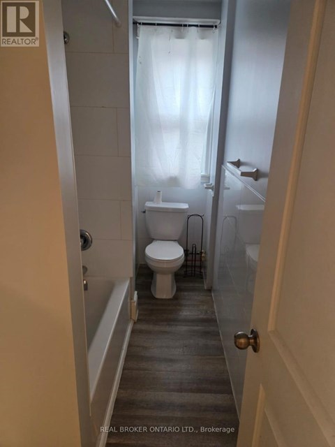 A bathroom with a toilet, sink and bathtub.