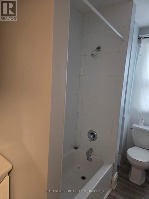 A white toilet is next to a white bathtub in a bathroom.