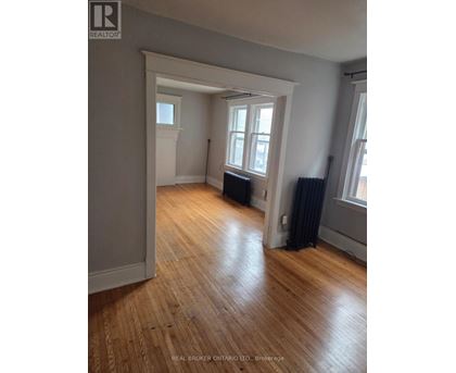 A room with wooden floors and a window with black curtains.