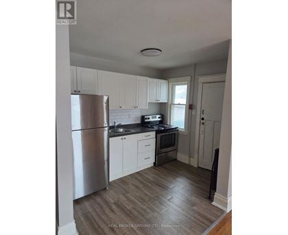 A kitchen with white cabinets and a stainless steel refrigerator.