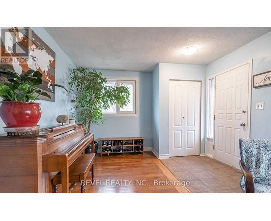 A living room with a piano, two doors, and a plant.