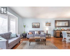 A living room with a grey couch, a coffee table, and a mirror on the wall.