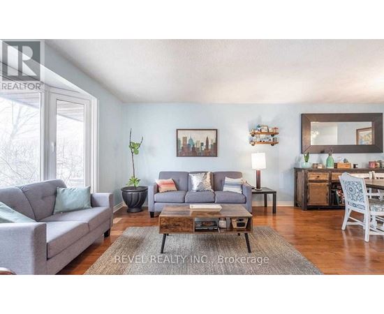 A living room with a grey couch, a coffee table, and a mirror on the wall.