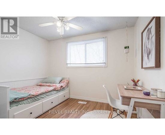 A bedroom with a bed, desk, and chair.