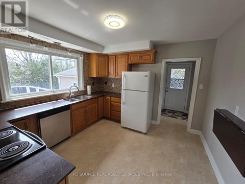 A kitchen with a white fridge and wooden cabinets.