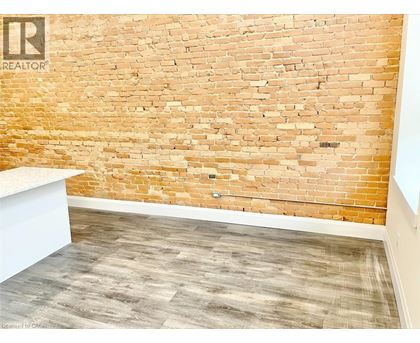 A room with a brick wall and wooden floor.