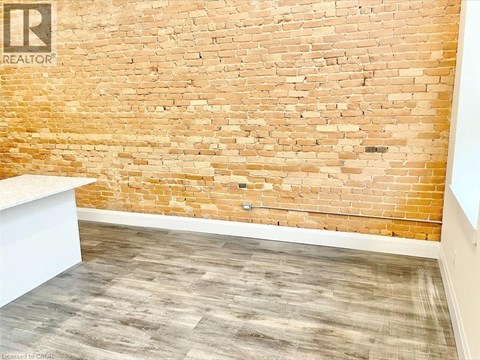 A room with a brick wall and wooden floor.