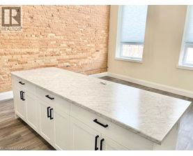A kitchen with a white countertop and cabinets.