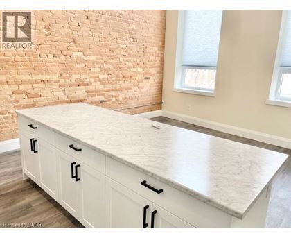 A kitchen with a white countertop and cabinets.