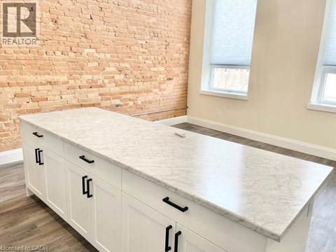A kitchen with a white countertop and cabinets.
