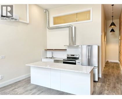 A modern kitchen with white cabinets and stainless steel appliances.