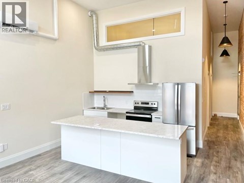 A modern kitchen with white cabinets and stainless steel appliances.