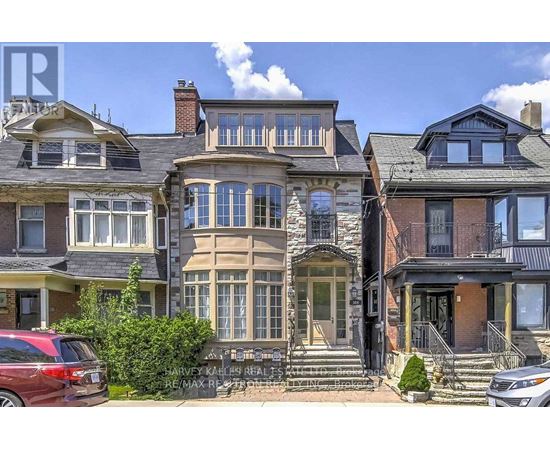 A row of houses with a car parked in front of them.