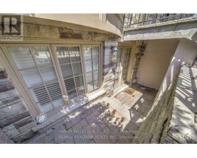 A balcony with a table and chairs is seen from above.