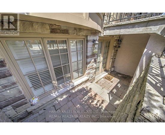A balcony with a table and chairs is seen from above.