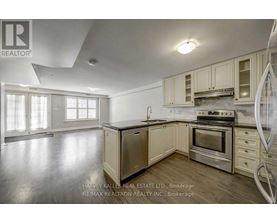 A kitchen with a refrigerator, oven, and cabinets.