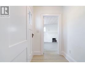 A hallway with a door leading to a living room.