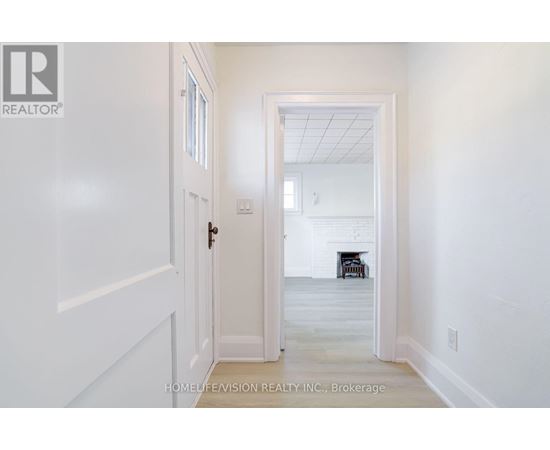 A hallway with a door leading to a living room.