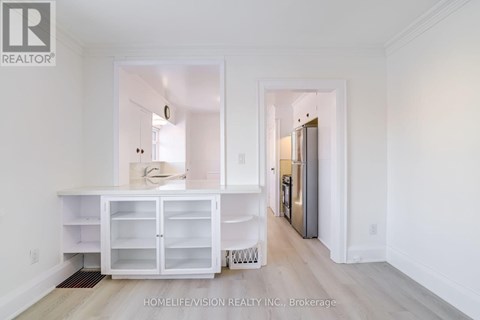 A white kitchen with a refrigerator and cabinets.