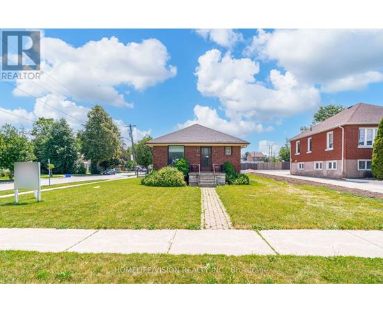 A realtor sign is in front of a grassy area with a house in the background.