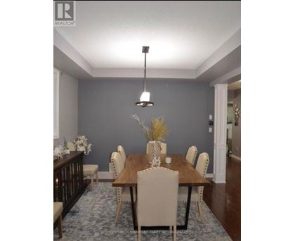 A dining room with a wooden table and chairs.