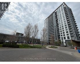 A modern apartment building with a parking lot in front.