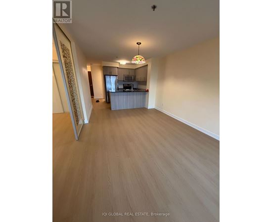 A spacious room with wooden flooring and a television in the corner.