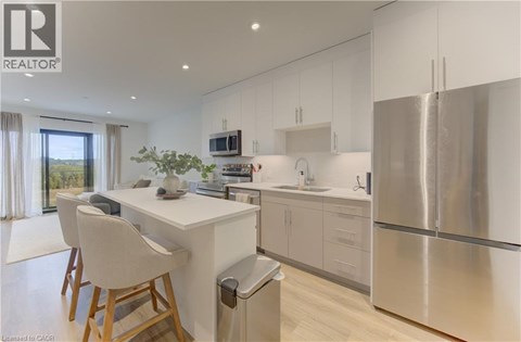 A modern kitchen with white cabinets and stainless steel appliances.