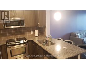 A modern kitchen with a stove top oven, microwave, and a granite counter top.