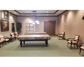 A bedroom with a bed, chairs, and a painting on the wall.