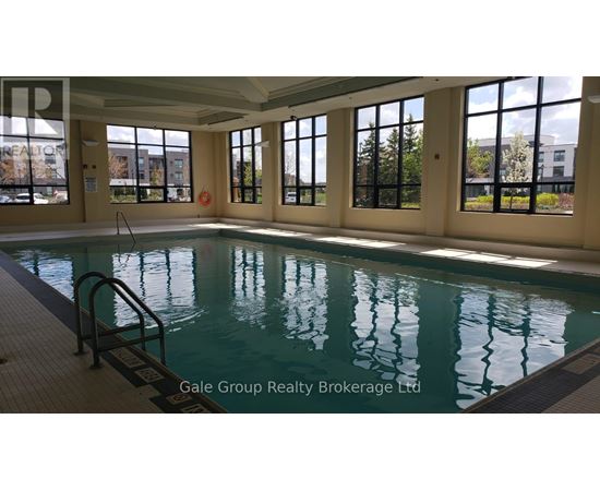 A large indoor swimming pool with a ladder on the side.