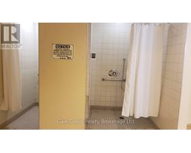 A bathroom with a shower curtain and a sign on the door.