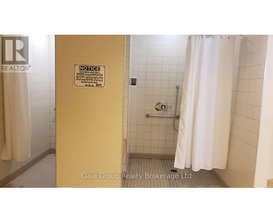 A bathroom with a shower curtain and a sign on the door.
