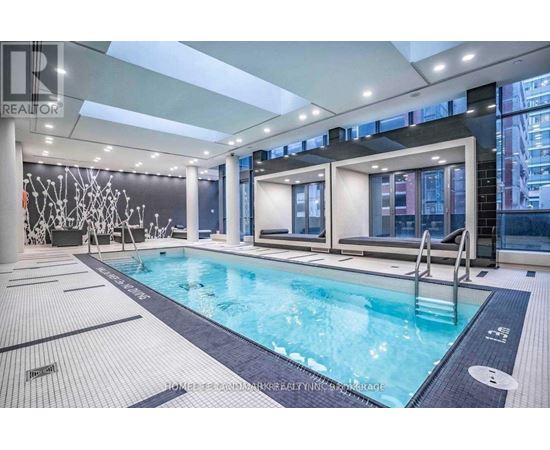A large indoor swimming pool with a tiled floor and a glass wall.