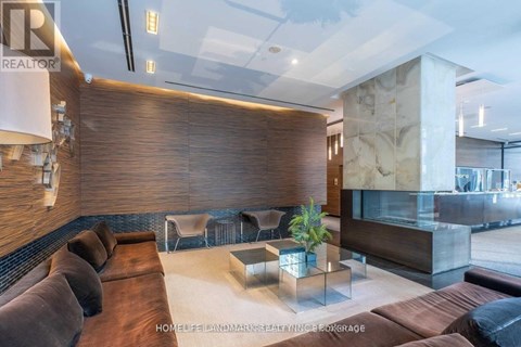 A modern living room with a brown sofa and a glass table.