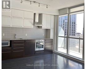 A kitchen with a window overlooking a cityscape.