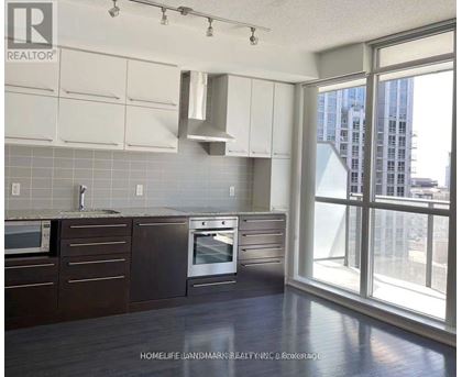 A kitchen with a window overlooking a cityscape.