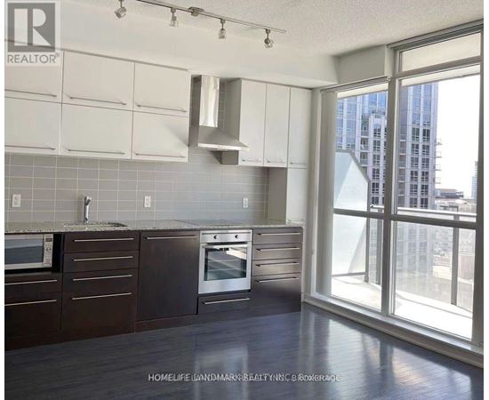 A kitchen with a window overlooking a cityscape.