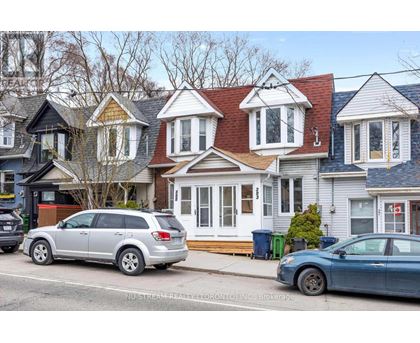 A silver SUV is parked in front of a house with a blue car parked in front of it.