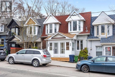 A silver SUV is parked in front of a house with a blue car parked in front of it.