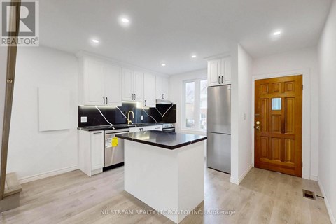 A kitchen with white cabinets and a black countertop.