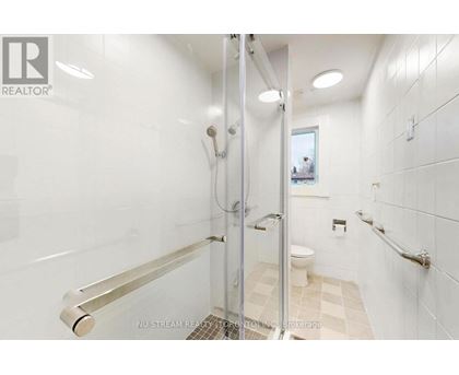 A white bathroom with a walk-in shower and a toilet.